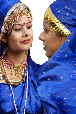 Two Young Lady Dancers each complimenting each other with the costumes they wore standing off the stage having fun takeing pictures with tourists